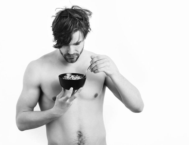 Caucasian sexy young macho holding black bowl with pasta - Zdjęcie, obraz