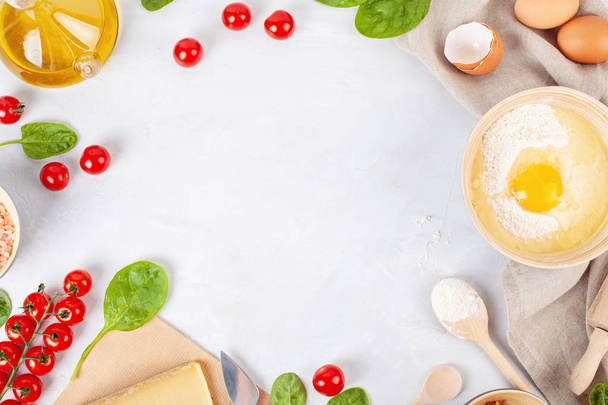 Ingredientes alimentares frescos e utensílios de cozinha para piza ou torta salgada
 - Foto, Imagem