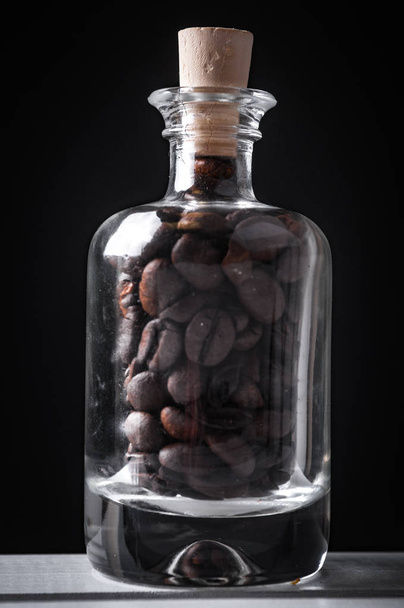 glass jar with coffee beans inside, cork bottle cap on top - Фото, изображение