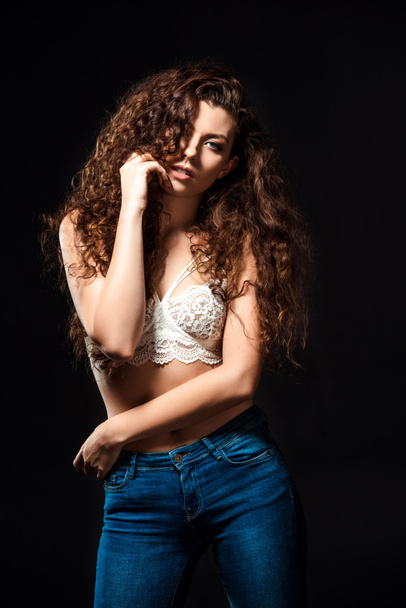 portrait of beautiful woman in white bra and jeans posing isolated  on black - Foto, Bild