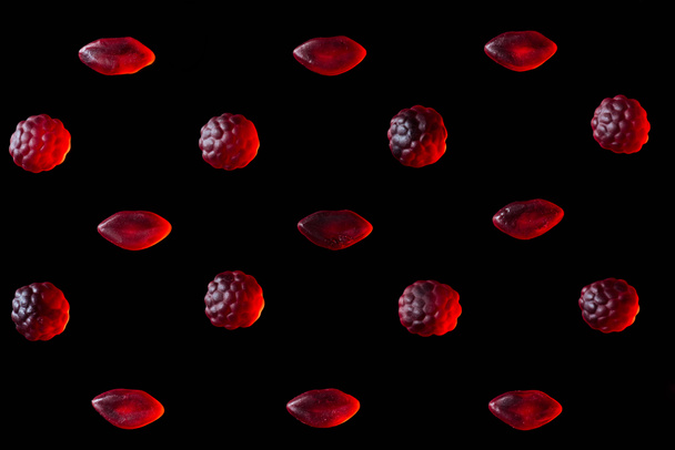 Set roter Gelee-Bonbons in Form von Himbeeren und Lippen isoliert auf schwarz - Foto, Bild