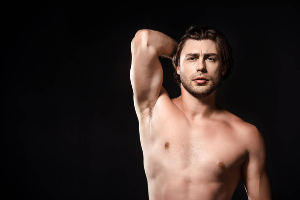 portrait of handsome shirtless man looking at camera isolated on black - Foto, immagini