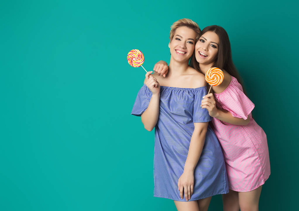 Due ragazze attraenti con lecca-lecca in mano
 - Foto, immagini