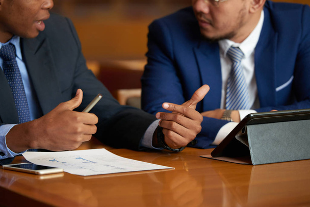 Обрезанный имидж бизнесменов, обсуждающих финансовый отчет на совещании
 - Фото, изображение