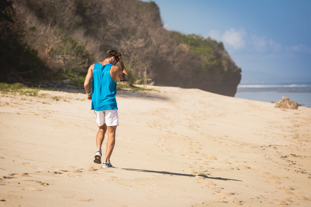 back view of sportsman walking on beach, Bali, Indonesia - Фото, зображення