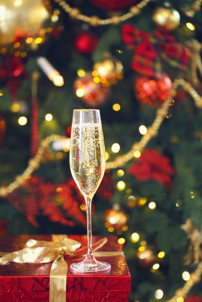 Verre avec champagne sur le présent près du sapin de Noël sur le fond. Fermer u
 - Photo, image