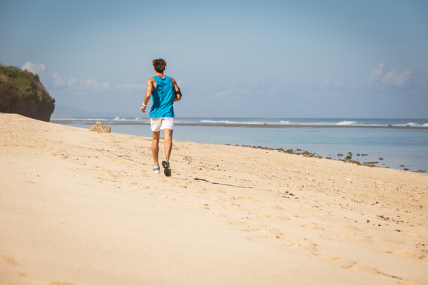 back view of jogger on sea shore, Bali, Indonesia - Photo, Image