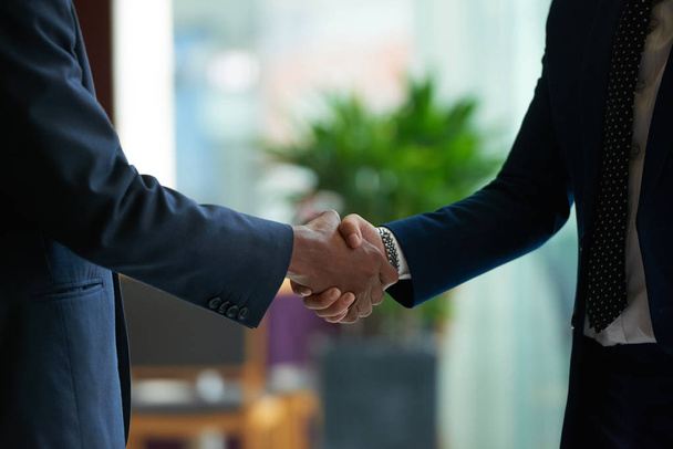 Business people shaking hands to confirm deal, cropped image  - Foto, afbeelding
