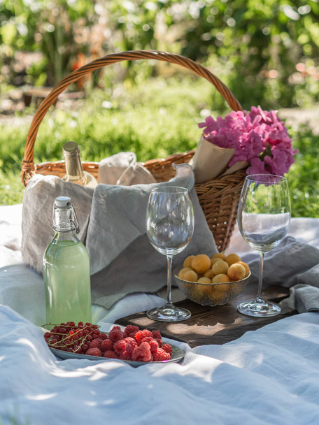 Eväskorin lähikuva juomilla, hedelmillä ja kukilla ruoholla
 - Valokuva, kuva