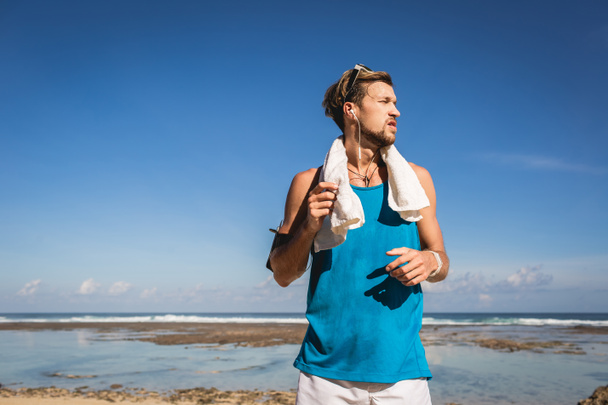 athletic man in sportswear with towel standing at sea - Φωτογραφία, εικόνα
