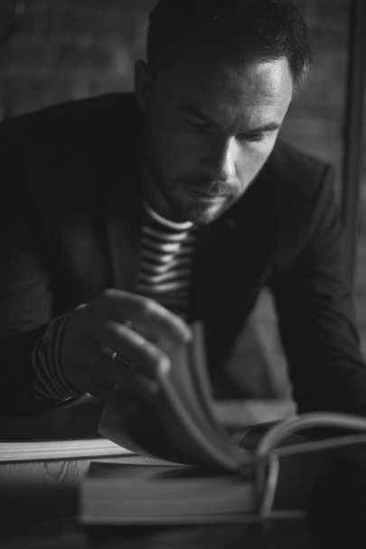 Black and white portrait of handsome stylish man in jacket. Man reading the book. - Φωτογραφία, εικόνα