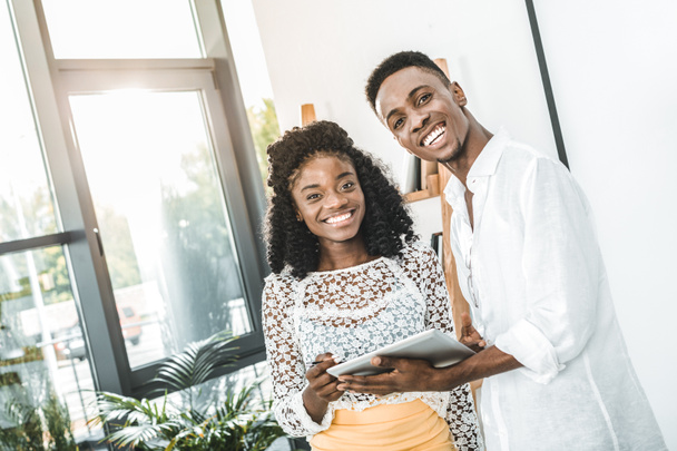 portrait of smiling african american business people with tablet in hands looking at camera - Foto, Bild