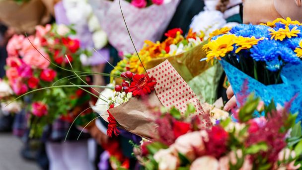 Bouquets di fiori in mani di bambini, vacanza di ritorno a scuola
 - Foto, immagini