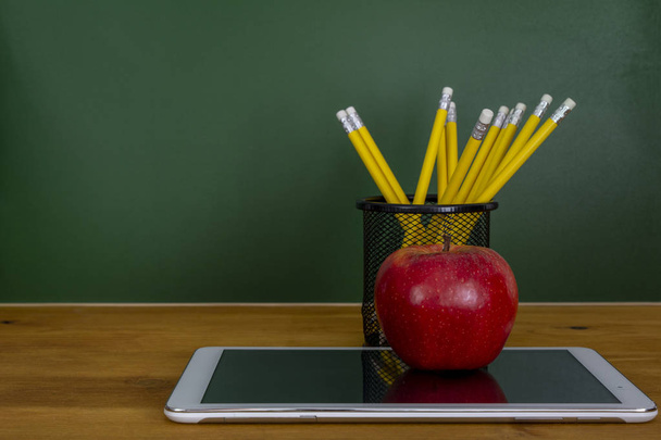 Back to school background with tablet, pencils and red apple over chalkboard - Photo, Image