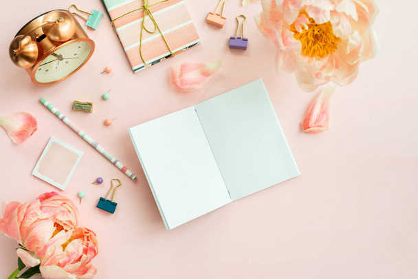 Empty Notebook for writing Dreams and Ideas, with different Stationery, and Big Pink Peony flowers laying on Pink background. Top View. Idea of Girly Office settings. Flat lay style. - Photo, Image