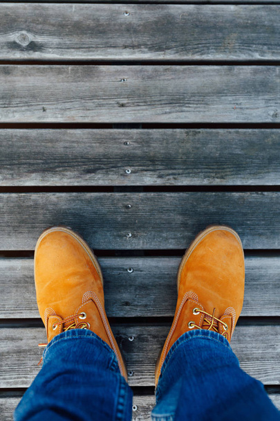 yellow winter boots on wooden planks background - Photo, Image