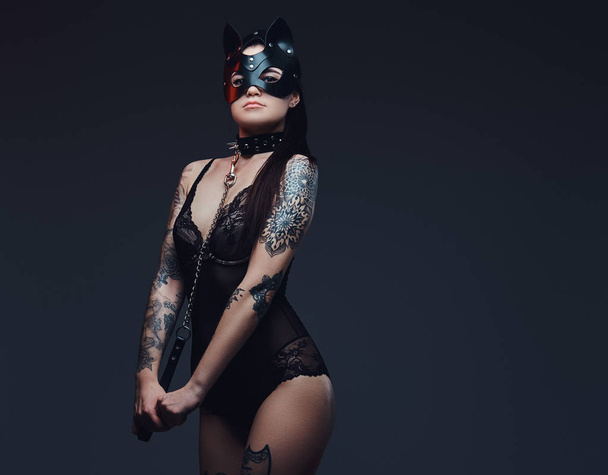 黒のランジェリー Bdsm 猫革マスクで暗い背景にポーズのアクセサリーを身に着けているセクシーな女性.  - 写真・画像