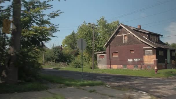 Közelről: Vezetés, elhagyott romos haza szegény környéken, Detroit, Amerikai Egyesült Államok a múlt rossz repedt utcán. Üres, elhagyott ház napos külvárosokban. Törött és kopott aszfalt pusztuló város lyukak - Felvétel, videó