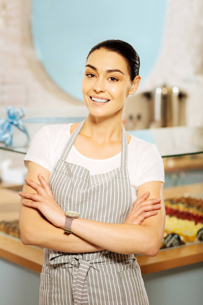 Smiling young confectioner looking happy while working - Фото, изображение