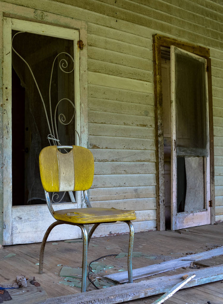 Żółty krzesło na werandzie domu opuszczonym młynie - Zdjęcie, obraz