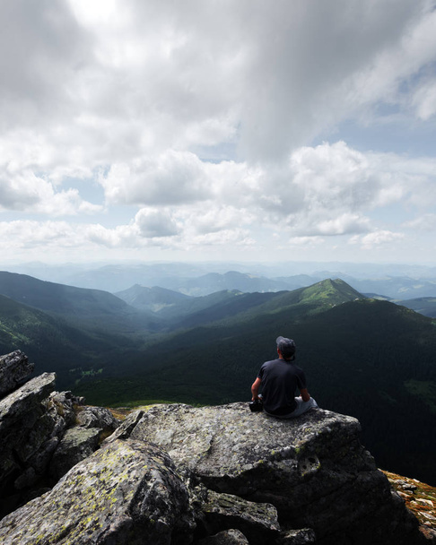 Un turista solitario sentado en el borde del acantilado
 - Foto, imagen