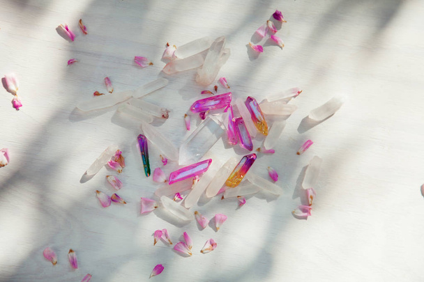 Colorful quartz crystals with pink rose leaves on wooden structure, flat lay background  - Φωτογραφία, εικόνα