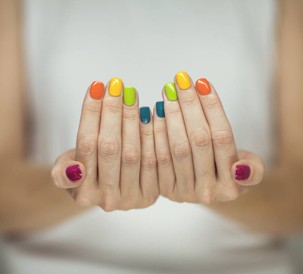 Beautiful woman hands with colorful rainbow nail polish, can be used as background - Фото, зображення
