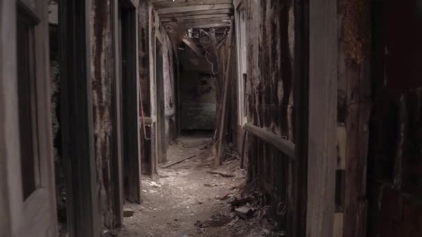 FPV CLOSE UP: Exploring decaying abandoned building with crumbling walls and collapding ceilings. Прогулка по темному узкому коридору мимо жутких темных комнат в разрушенном разрушающемся опасном доме
 - Кадры, видео