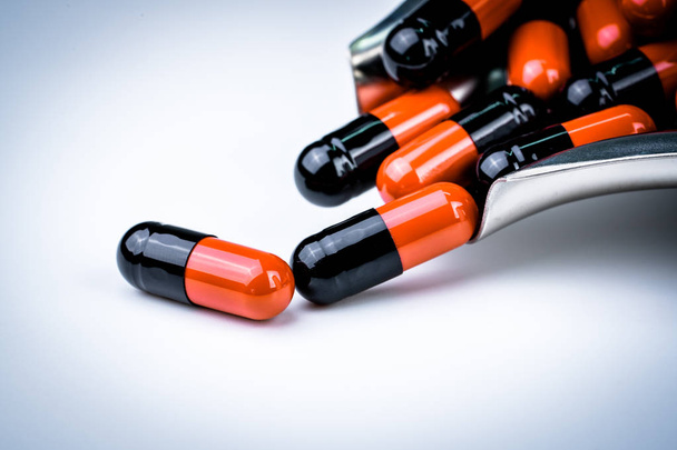 Focus selettivo di pillole di capsule arancioni e nere su vassoio di droga in acciaio inossidabile. Resistenza agli antibiotici. Sanità globale. Resistenza agli antibiotici farmaci. Pillole antimicrobiche per capsule. Sfondo farmacia
 - Foto, immagini