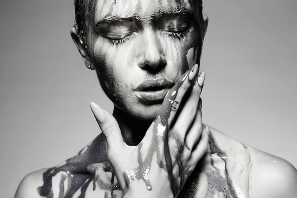 Girl in Paint. Young woman with Dirty Face. liquid paint flowing over a beautiful face and Body - Photo, Image