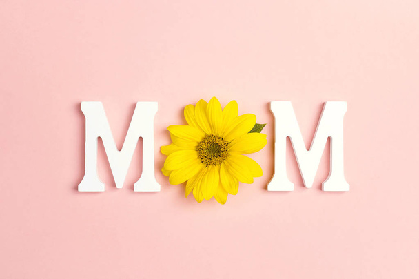 Word Mom with Yellow sunflowers on pink background. Mother's Day or women's day concept. Top view. - Foto, immagini