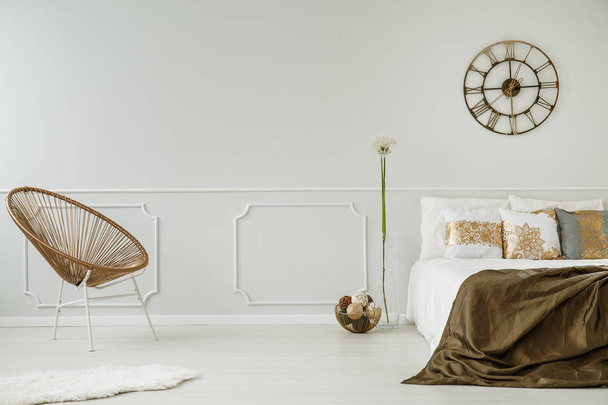 Moderno sillón, reloj y cama doble en un glamour interior dormitorio. Lugar para tu pintura. Foto real
 - Foto, Imagen