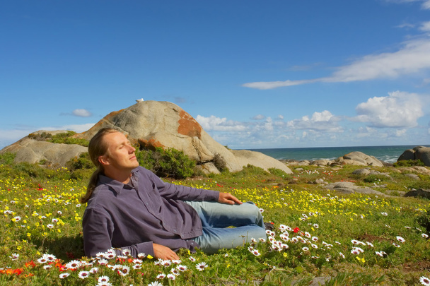 Young man relaxes lying on flower field - Photo, Image