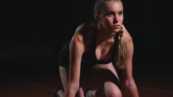 Atleta feminina em um fundo escuro está se preparando para executar o sprint cross-country das almofadas na esteira em um fundo escuro
 - Filmagem, Vídeo