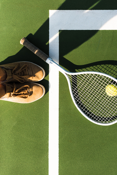 partial view of female tennis player standing near tennis racket and ball on court - Photo, Image