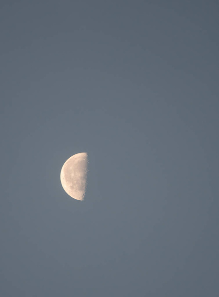 Una mezza luna vista alla luce del giorno sopra la lettura
 - Foto, immagini