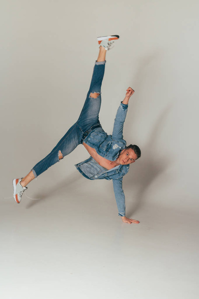 shot of jump feet up, of mad, crazy, cheerful, successful, lucky guy in casual outfit, jeans, jumping with hands up, triumphant, gesturing against white background, sport - Foto, imagen