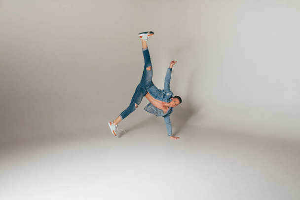 shot of jump feet up, of mad, crazy, cheerful, successful, lucky guy in casual outfit, jeans, jumping with hands up, triumphant, gesturing against white background, sport - Фото, изображение
