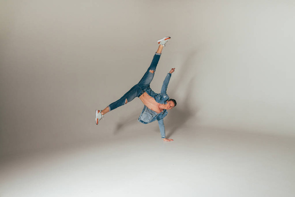 shot of jump feet up, of mad, crazy, cheerful, successful, lucky guy in casual outfit, jeans, jumping with hands up, triumphant, gesturing against white background, sport - Photo, image