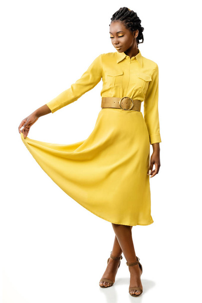 Ritratto a figura intera di attraente giovane donna afroamericana con gli occhi chiusi tenendo fine del vestito isolato su sfondo bianco
. - Foto, immagini
