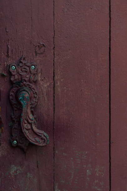 крупным планом вид старинной декоративной дверной ручки на старой деревянной двери
 - Фото, изображение