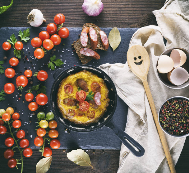 sartén redonda con tortilla frita, huevos batidos con tomates cherry, vista superior
 - Foto, Imagen