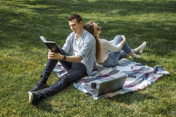 Cheerful man and woman resting in nature after learning. - Photo, Image