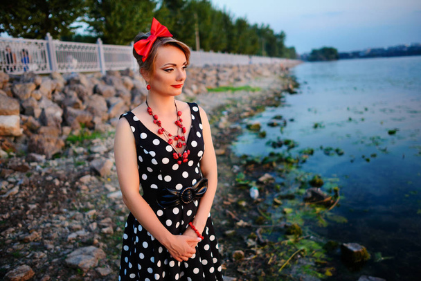 Uma bela jovem vestida em pé junto ao lago
. - Foto, Imagem
