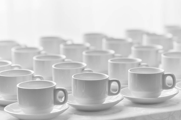 Top view on many stacked in rows of empty clean white cups for tea or coffee. Close-up. Background - 写真・画像