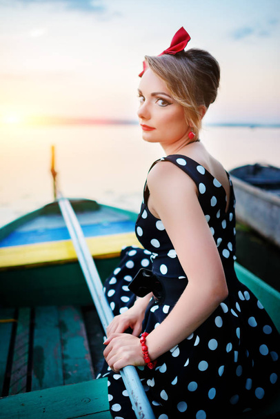 Mulher bonita vestida em um barco em uma margem do lago
. - Foto, Imagem