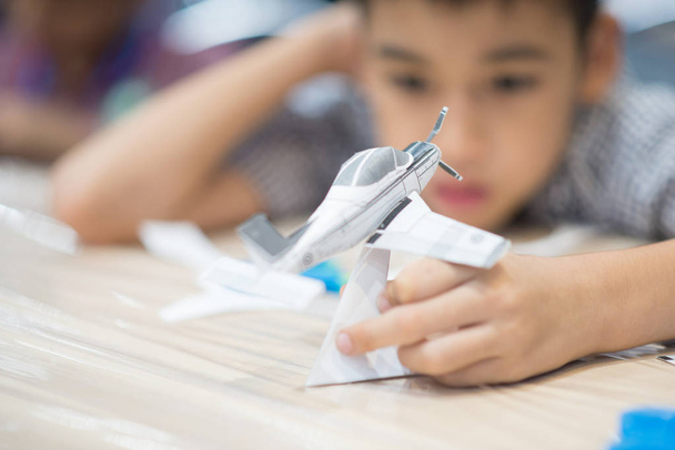 Little boy making an aircraft paper - Foto, imagen