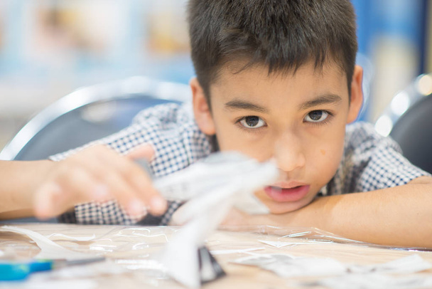 Little boy making an aircraft paper - Photo, Image