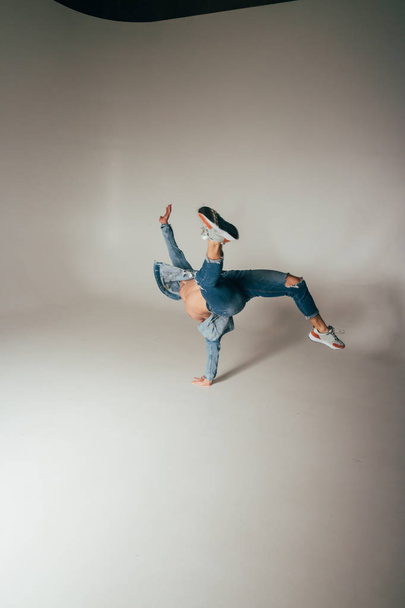 shot of jump feet up, of mad, crazy, cheerful, successful, lucky guy in casual outfit, jeans, jumping with hands up, triumphant, gesturing against white background - 写真・画像