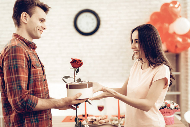 Guy Makes A Gift To Girlfriend On Valentine's Day. Love Each Other. Sweetheart's Romantic Moment Concept. Young And Handsome. Happy Relationship. Feelings Showing. Present Holding. - Foto, afbeelding